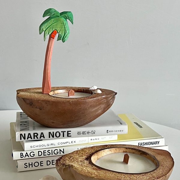 Natural coconut shell candle holder with a palm tree decoration